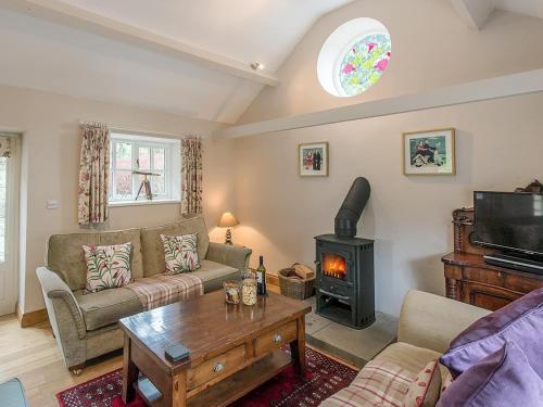 a living room with a couch and a stove at Walkmill Lodge in Wentnor