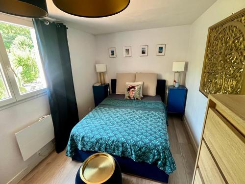 une petite chambre avec un lit avec une couette bleue dans l'établissement Maison 15min à pied du village de Saint Paul de Vence, à Saint-Paul-de-Vence