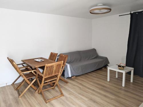 un salon avec un canapé, une table et des chaises dans l'établissement Le barracuda du port, à Port-la-Nouvelle