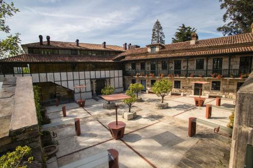 an old building with a courtyard with a table and benches at Pazo da Merced in Neda