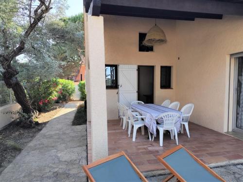 une table et des chaises assises sur une terrasse dans l'établissement Villa et jardin de charme, à 5 mn de la plage, au Barcarès