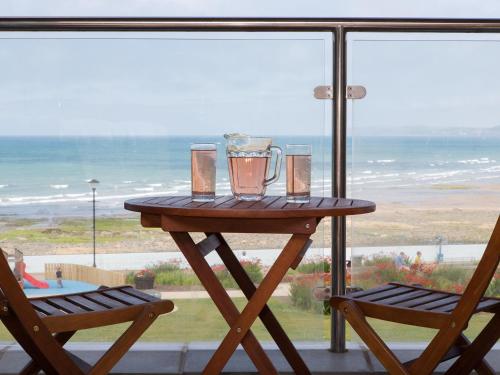 Una mesa con una licuadora y dos sillas frente a una ventana. en Apartment 5 Latitude 51 Westward Ho!, en Westward Ho