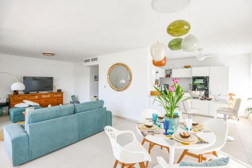 un salon avec un canapé bleu et une table dans l'établissement Le Prado - Appart haut standing 2 ch avec terrasse, à Marseille