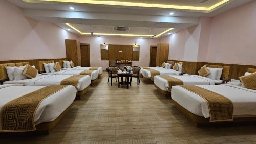 a row of beds in a room with a table at The Royal Bihar in Patna