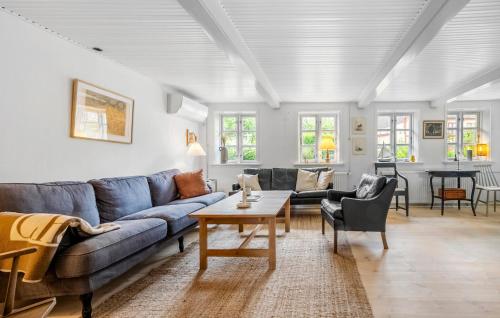 a living room with a couch and a table at Cozy Home In Allinge With Kitchen in Allinge