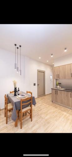 a living room with a table and a kitchen at Pnoe Home Tinos in Tinos