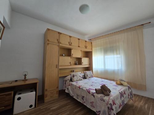una piccola camera da letto con un letto e una finestra di La Casa de Ely a Sant Carles de la Ràpita