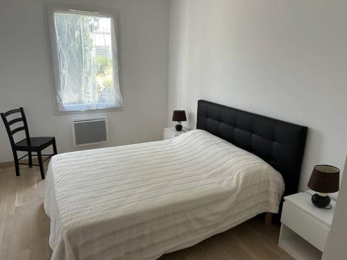 une chambre avec un lit avec une tête de lit noire et une fenêtre dans l'établissement Appartement T3 cosy avec jardin à deux pas du centre de Meschers, garage et animaux admis - FR-1-738-1, à Meschers-sur-Gironde