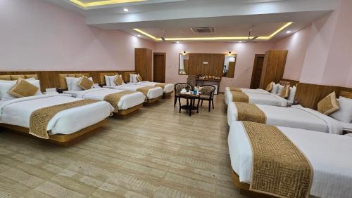 a hotel room with four beds and a table at The Royal Bihar in Patna