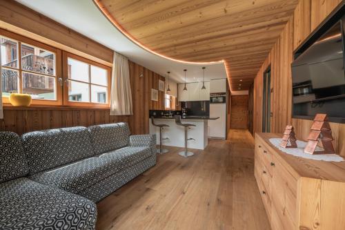 a living room with a couch and a kitchen at Mountainlodge Luxalpine in San Vigilio Di Marebbe