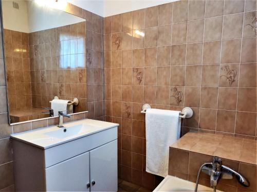 une salle de bain avec un lavabo et un miroir dans l'établissement Villa et jardin de charme, à 5 mn de la plage, au Barcarès