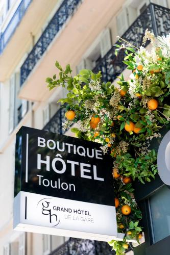 un panneau indiquant un hôtel de caractère devant un bâtiment dans l'établissement Grand Hôtel de la Gare Toulon - Boutique Hôtel, à Toulon