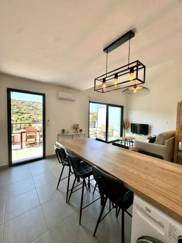 - un salon avec une grande table et des chaises en bois dans l'établissement Duplex en résidence, à Propriano