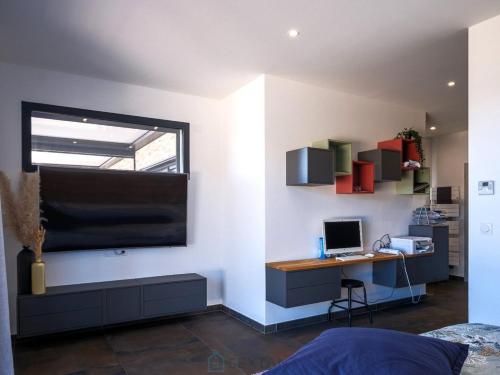 Cette chambre comprend un bureau et un ordinateur mural. dans l'établissement Villa Baverde Luxury, à Istres