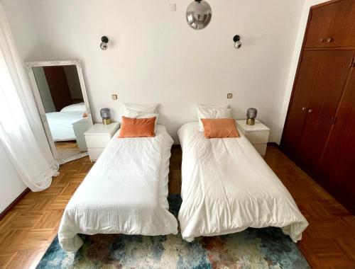 two beds in a room with a mirror at Cozy large rooms in Minde, Fatima in Minde