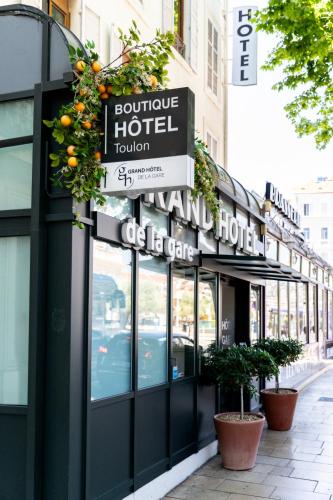 un bâtiment avec un panneau indiquant un hôtel dans une rue dans l'établissement Grand Hôtel de la Gare Toulon - Boutique Hôtel, à Toulon