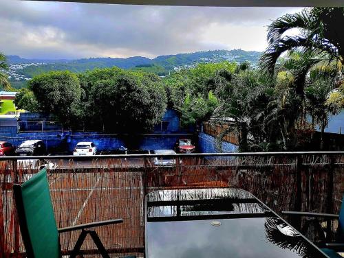 Un balcón con vista a una calle y árboles. en K A Z - Les flamboyants, en Saint-Denis