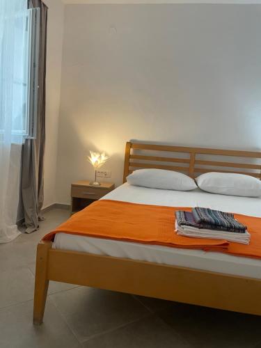 a bedroom with a bed with an orange blanket at Apartments Goldie in Senj