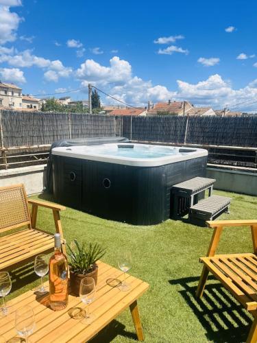 une arrière-cour avec un bain à remous et une table avec des verres à vin dans l'établissement Appartement d'exception avec jacuzzi 160m2, à Pertuis