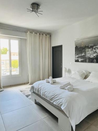une chambre blanche avec un grand lit et une fenêtre dans l'établissement Appartement d'exception avec jacuzzi 160m2, à Pertuis