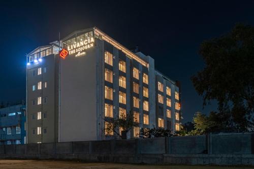 a hotel building with a sign on it at night at TGI Livancia The Sojourn in Bengaluru