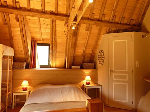 ein Schlafzimmer mit einem Bett in einem Holzhaus in der Unterkunft Kêr Neizh Breizh - Gîtes de Charme - Le Petit Châtelier in Saint-Samson-sur-Rance