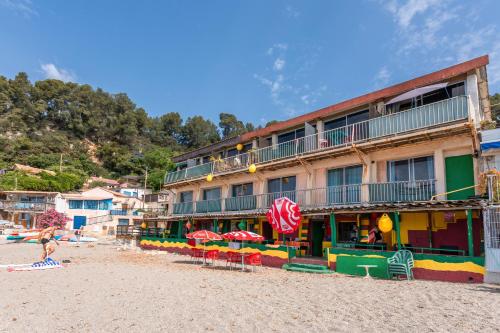 un hôtel sur la plage avec des chaises et des parasols dans l'établissement Appartement Escaliers, au Pradet