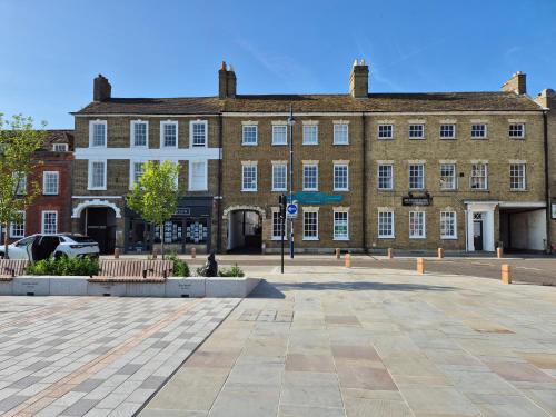 a large brick building with benches in front of it at Stunning & spacious Georgian town house in St Neots town centre with parking in Saint Neots