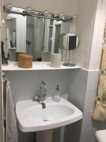 une salle de bain avec un lavabo et un miroir dans l'établissement Studio à 2 pas du métro, à Paris