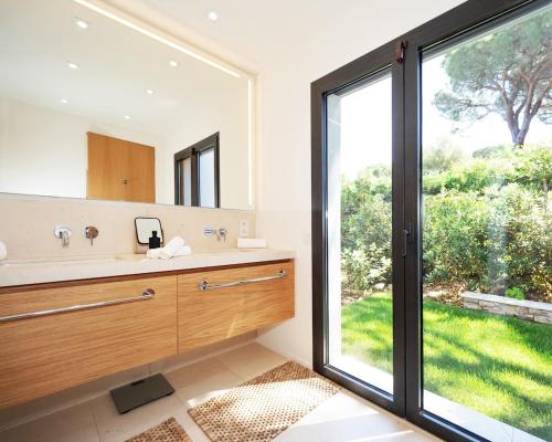 une salle de bain avec un lavabo et une grande fenêtre dans l'établissement Villa Le Tourmentin, à Saint-Tropez