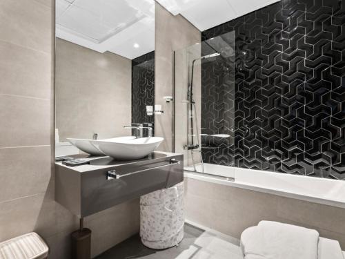 une salle de bain avec un lavabo et une douche dans l'établissement Contemporary and Spacious 1-Bedroom in AG tower - Business Bay, à Dubaï