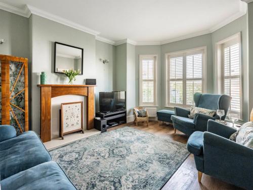 Una sala de estar con chimenea y televisión. en Turnstone House, en Gorleston-on-Sea