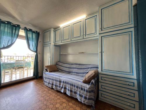 une chambre avec un lit et une grande fenêtre dans l'établissement Studio Cabine Avec Piscine & Parking - Gruissan - FR-1-229-56, à Gruissan