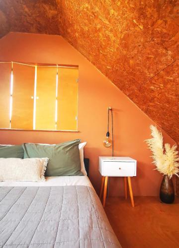 a bedroom with a bed with an orange wall at Gwynn Lodge in Newquay