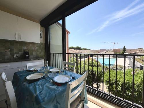 une table de salle à manger avec vue sur un balcon dans l'établissement Studio Cabine Avec Piscine & Parking - Gruissan - FR-1-229-56, à Gruissan