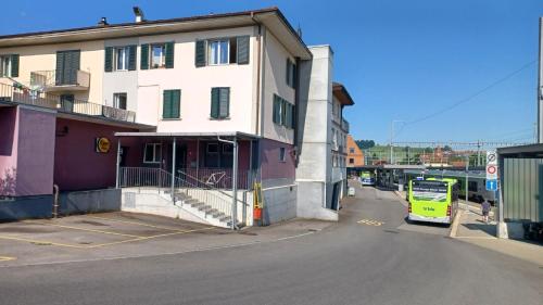 un autobus giallo parcheggiato accanto a un edificio su una strada di Gasthof Ochsen a Huttwil