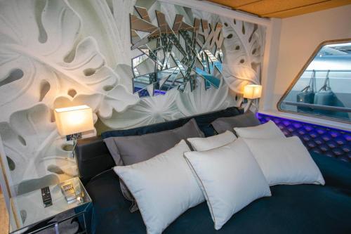 - une chambre avec un canapé et un mur orné d'une fresque murale dans l'établissement Superbe Expérience à bord!, à Menton