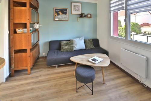 un salon avec un canapé et une table dans l'établissement A cozy hideaway just 20 minutes from Paris, à Sartrouville