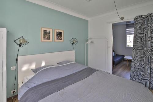 une chambre avec un lit et un mur bleu dans l'établissement A cozy hideaway just 20 minutes from Paris, à Sartrouville