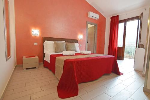 a bedroom with a large bed with a red blanket at Le Falesie di Castelluzzo in Castelluzzo