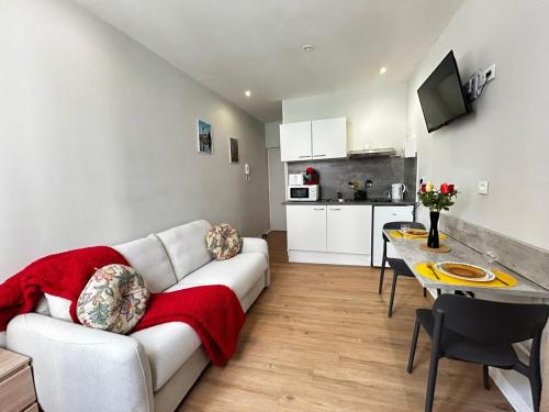 un salon avec un canapé et une table et une cuisine dans l'établissement Soif de Limoges, cosy en hypercentre, à Limoges