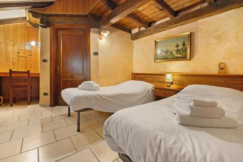 a room with two beds with towels on them at Arthemisia - Rhêmes-Notre-Dame in Rhêmes-Notre-Dame