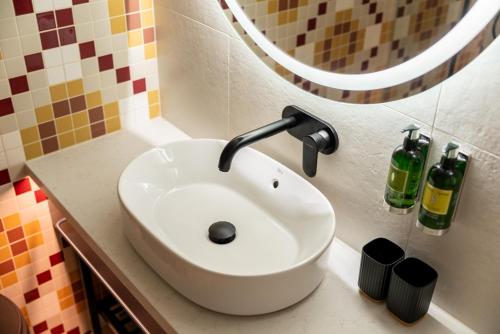 a white sink in a bathroom with a mirror at Malom és Kacsa Boutique Hotel in Tata