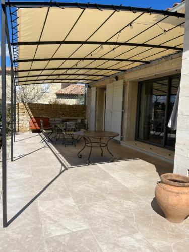 d'une terrasse avec une table et des bancs. dans l'établissement Maison dans un hameau avec piscine, à Gordes