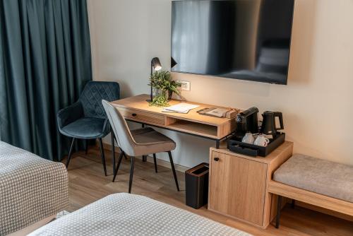 a room with a desk in a hotel room at Malom és Kacsa Boutique Hotel in Tata