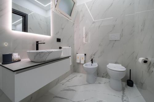 a white bathroom with a sink and a toilet at CrystalRooms in Leverano