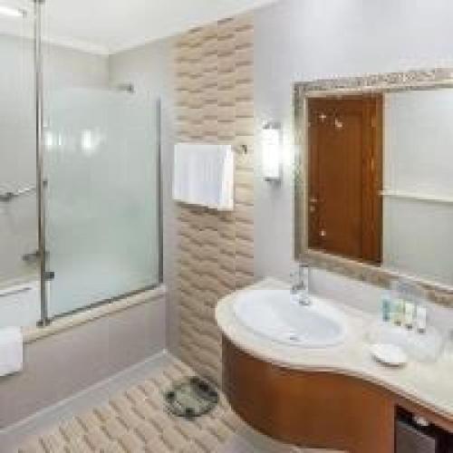 a bathroom with a sink and a shower and a mirror at Holiday International Hotel Embassy District by CMG in Dubai