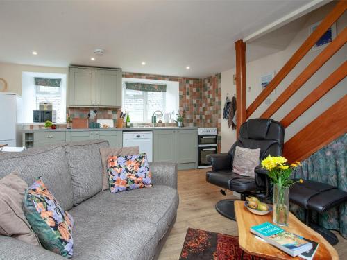 a living room with a couch and a kitchen at Garden Cottage in Kingsbridge