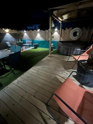 - un patio la nuit avec des tables et des chaises dans l'établissement La belle aventure, à Rivesaltes