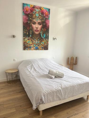 une chambre avec un lit avec un tableau sur le mur dans l'établissement La belle aventure, à Rivesaltes